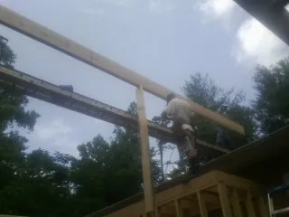 Carpenter setting a ridge beam over a new addition frame — Ice Dam Removal by Roofing Brothers in Chesapeake