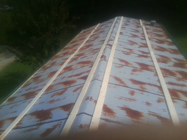 Rusted metal roof panels with new wood purlins before replacement — Storm Damage Roof Repair in Chesapeake by Roofing Brothers