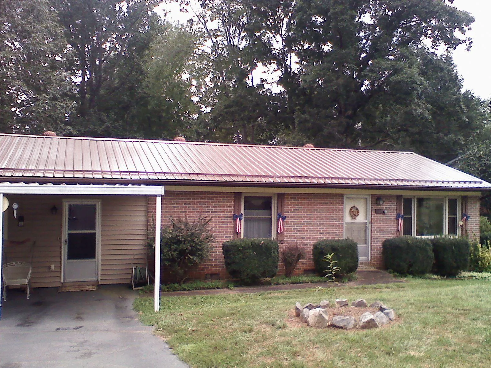 Bronze metal roof and carport on a brick ranch home — Roof Repair work by our crew in Chesapeake