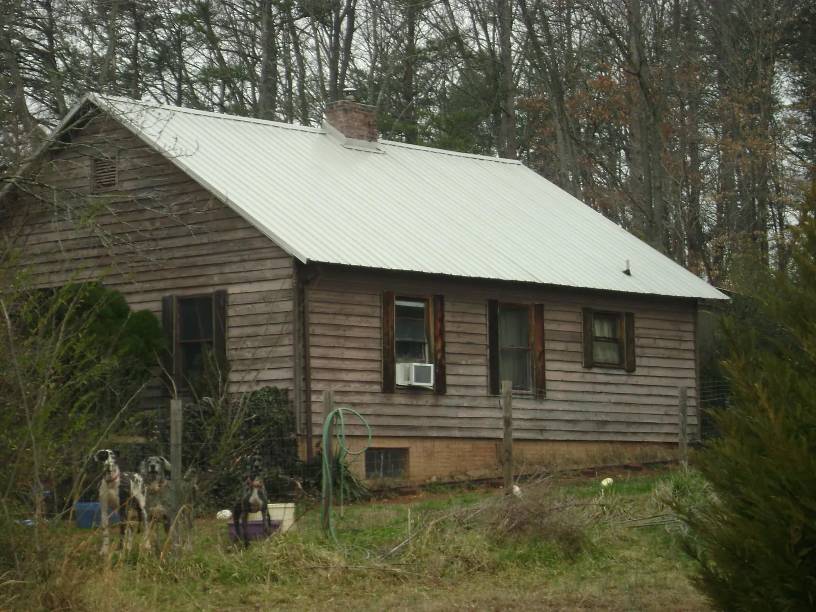White metal roof on an old wood sided farmhouse, from a Metal Roof Installation job in Chesapeake